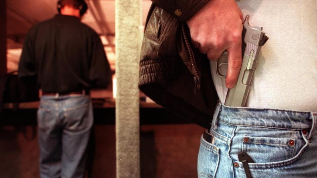 A gun owner displays where he keeps his concealed weapon.