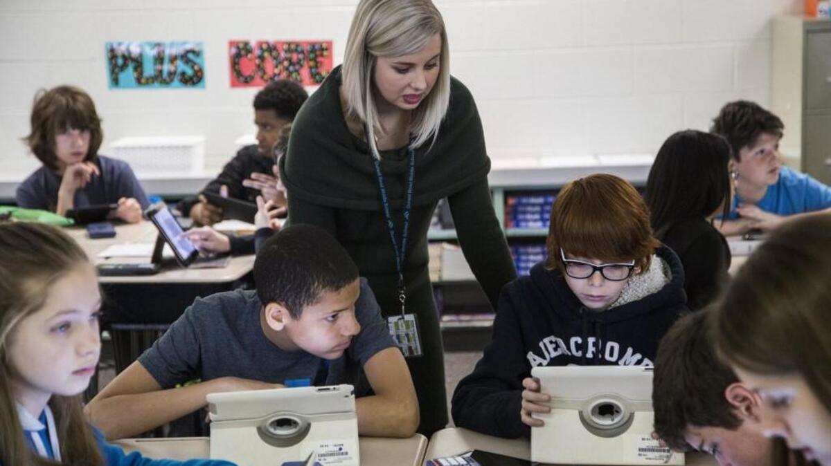 Durant Road Middle School teacher Alyssa Jackson helps seventh-graders Jayon Whitley, left, and Joe Abi-Najm during a lesson on statistics analyzing NCAA mens basketball seeds in the NCAA championship tournament Thursday, March 16, 2017.