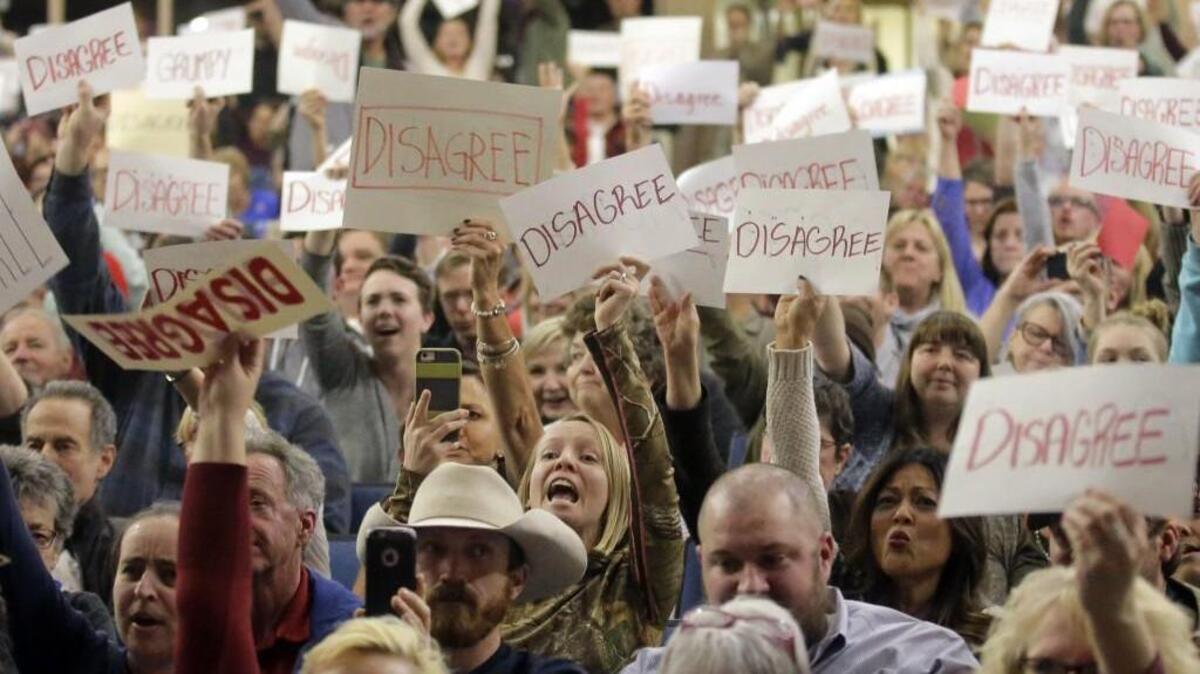 In this Thursday, Feb. 9, 2017 photo, people react as U.S. Rep. Jason Chaffetz speaks during a town hall meeting at Brighton High School in Cottonwood Heights, Utah. Some attendees of the contentious town hall hosted by Chaffetz last week, have sent the congressman fake invoices after he claimed some people there were paid protesters.
