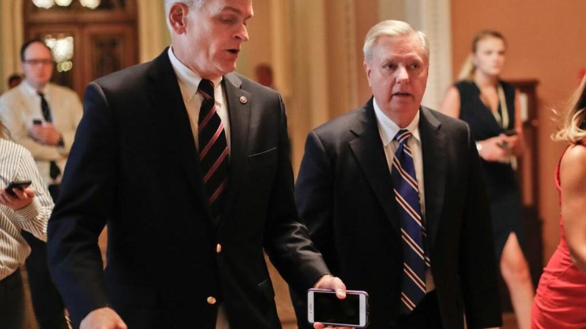 In this July 13, 2017, file photo, Sen. Bill Cassidy, R-La., left, and Sen. Lindsey Graham, R-S.C., right, talk while walking to a meeting on Capitol Hill in Washington. Senate Republicans are planning a final, uphill push to erase President Barack Obama's health care law. But Democrats and their allies are going all-out to stop the drive. Graham and Cassidy are leading the new GOP charge and they'd transform much of Obama's law into block grants and let states decide how to spend the money.