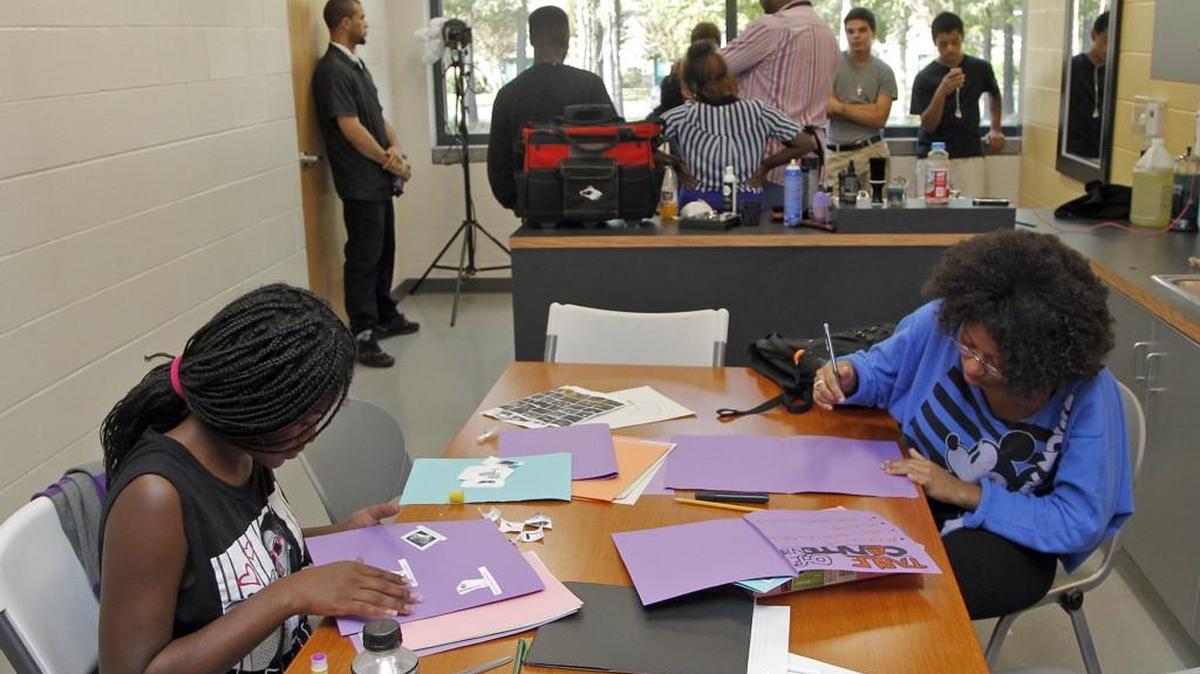 Jadaya Bunch, left, and Dallas Bonds, right, work on a school project while others learn about barbering and cosmetology at the Wake County Boys & Girls Clubs Teen Center in 2014.