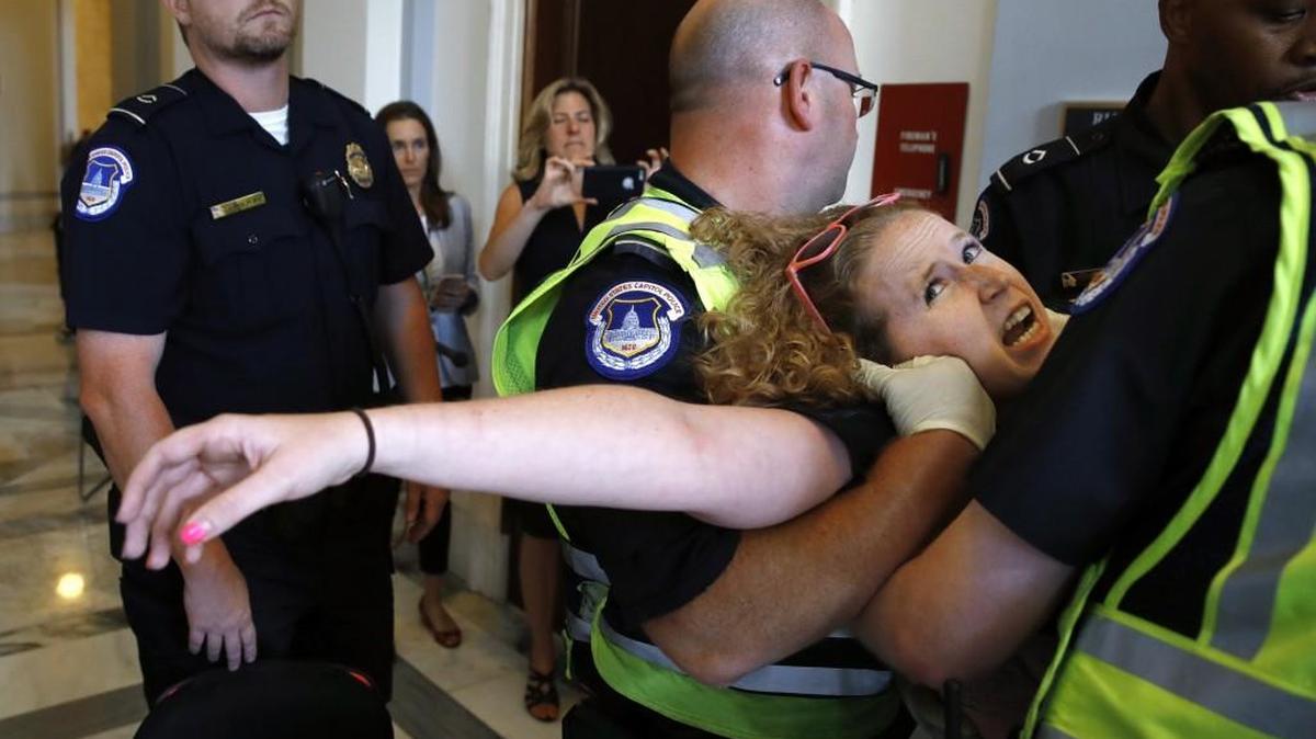 Stephanie Woodward, of Rochester, NY, who has spina bifida and uses a wheelchair, is removed from a sit-in at Senate Majority Leader Mitch McConnell's office as she and other disability rights advocates protest proposed funding caps to Medicaid on Thursday on Capitol Hill in Washington.