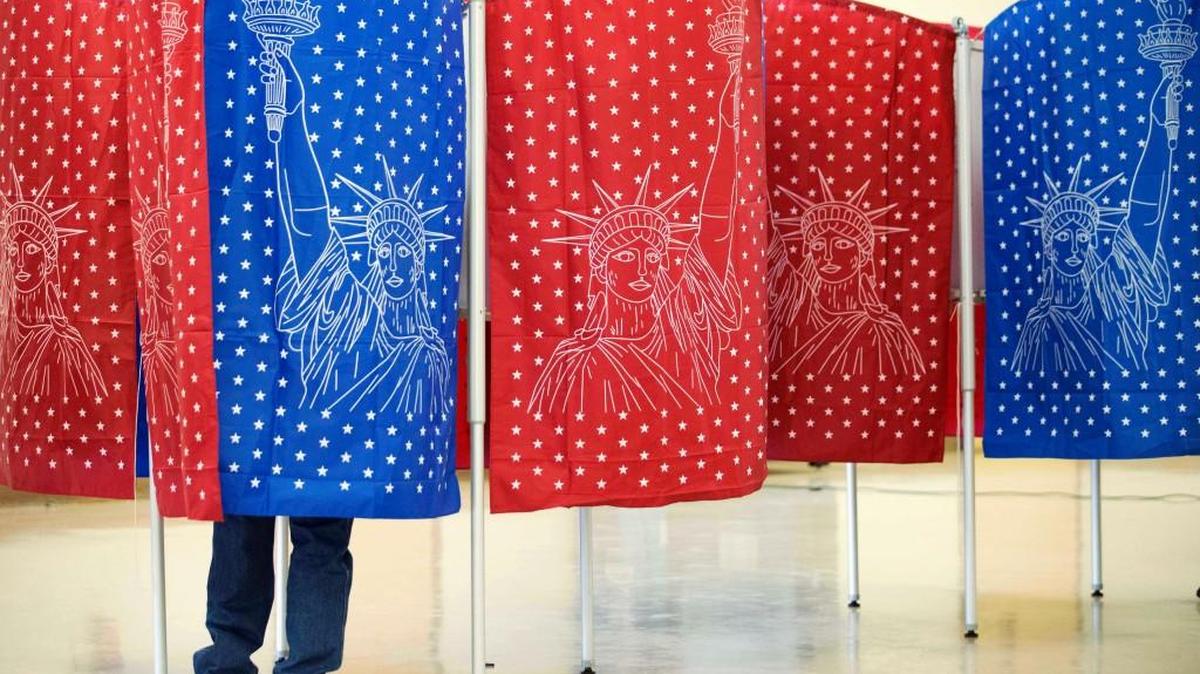 A voter marks a ballot for the New Hampshire primary inside a voting booth at a polling place in Manchester, N.H.