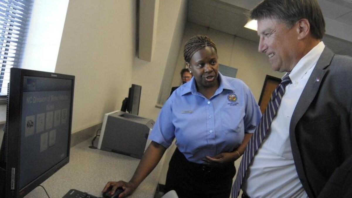 NCDMV senior examiner Darnette Evans demonstrates for NC governor Pat McCrory the technology in the newly opened DMV office in Huntersville in 2014.