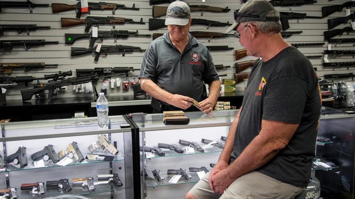 Mike Fiorille, business partner at Get Loaded, serves a customer at the gun store on June 30, 2016, in Grand Terrace, Calif. Inspections of firearms dealers by the Bureau of Alcohol, Tobacco, Firearms and Explosives are few and far between because of staff shortages.