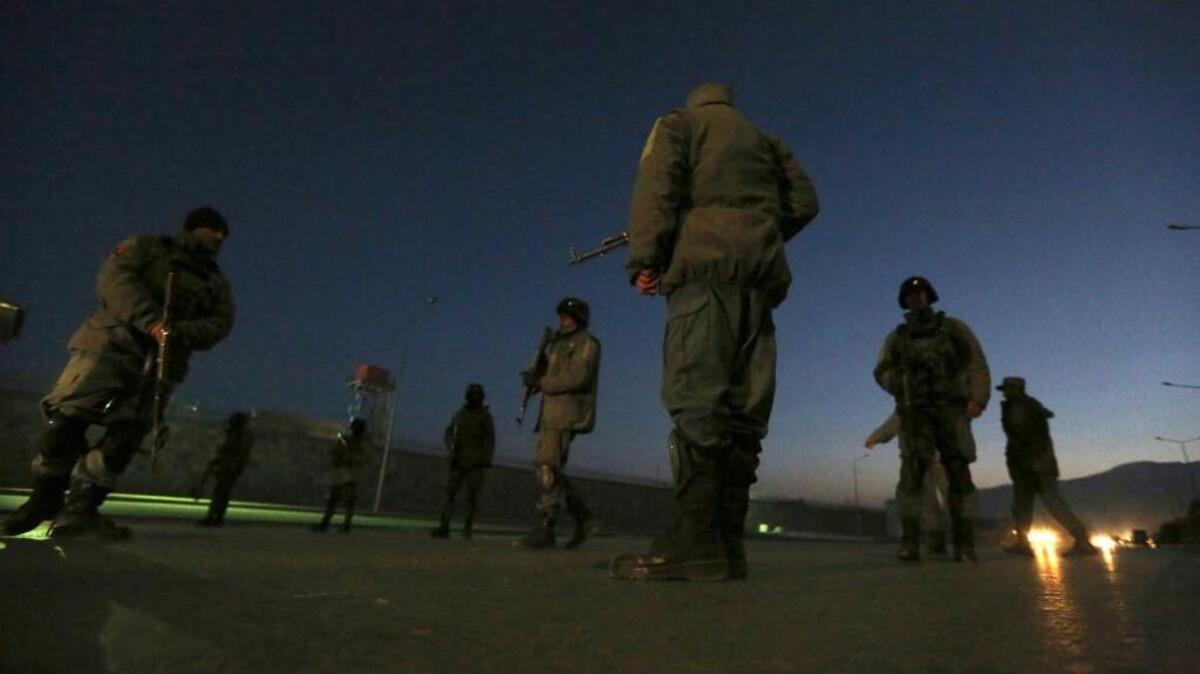 Afghan security forces stand guard near the site of two large bombings in Kabul, Afghanistan.