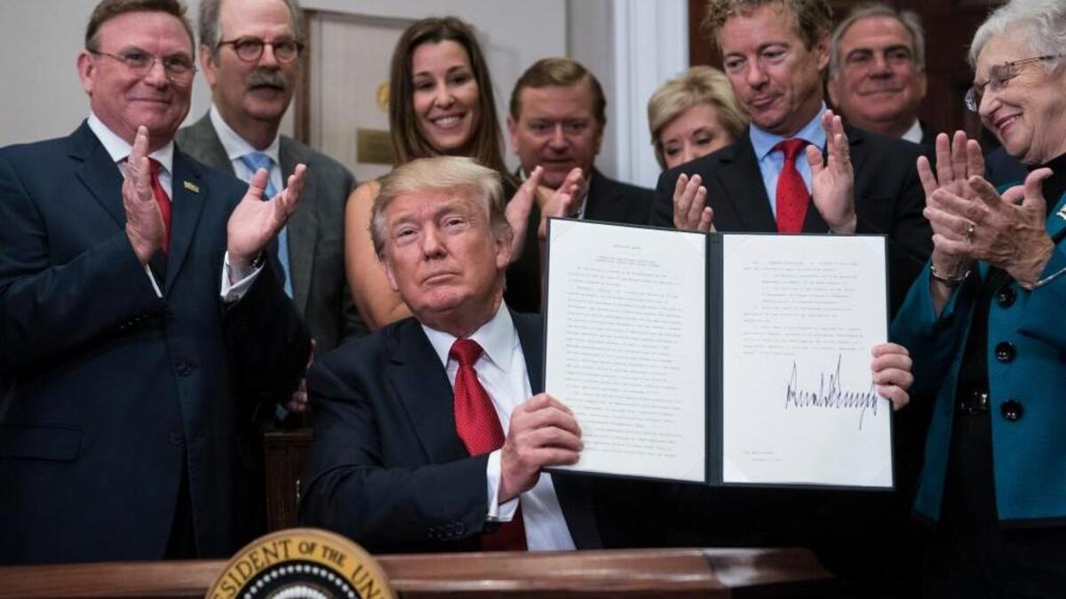 President Trump signs an executive order on health care the White House Thursday. MUST