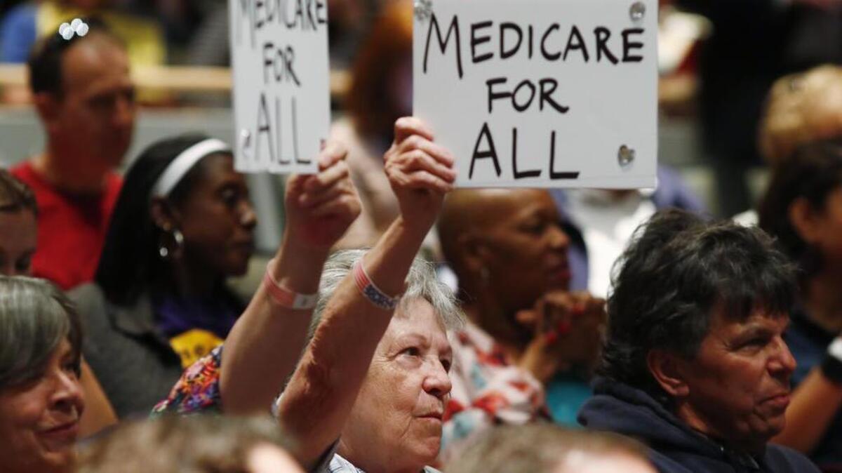 Constituents hold up placards as U.S. Rep. Mike Coffman, R-Colo., speaks during a town hall meeting in a hall on the campus of the University of Colorado Medical School late Wednesday, April 12, 2017, in Aurora, Colo. Town halls have become a risky proposition for GOP members of Congress since the election of President Donald Trump.