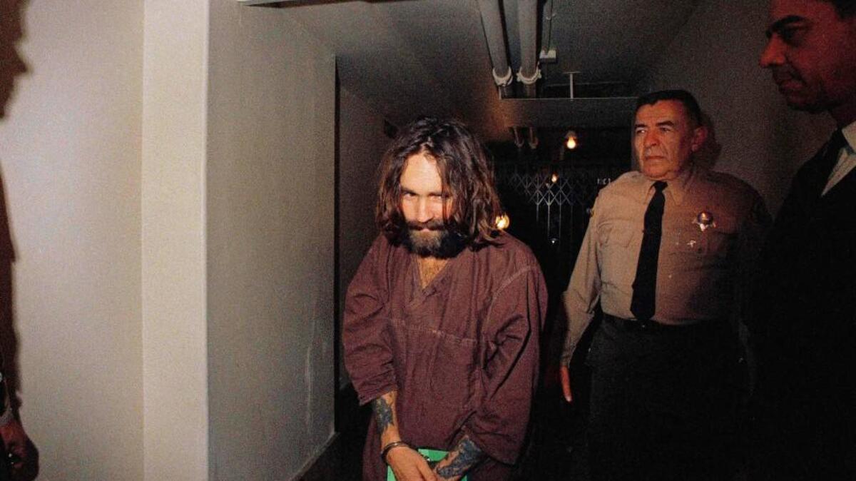In this 1969 file photo, Charles Manson is escorted to court in Los Angeles during an arraignment phase. Authorities say Manson, cult leader and mastermind behind 1969 deaths of actress Sharon Tate and several others, died on Sunday, Nov. 19, 2017. He was 83.