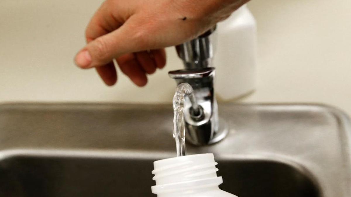 In this photo taken May 3, 2016, Donna McNeal, of Orion Environmental Services, collects a water sample from a classroom drinking fountain for lead testing at Fawcett Elementary School in Tacoma, Wash.