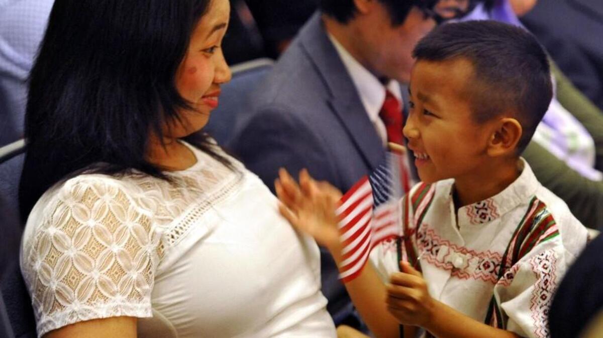 Cinn Niang, left, and her son Paumung, 5, sit with the other applicants before a naturalization ceremony in Jacksonville, Florida. Cinn is a Zomi refugee from Burma (Myanmar). The United States admitted 8,112 refugees from Burma between October and May, the highest number from any one country.