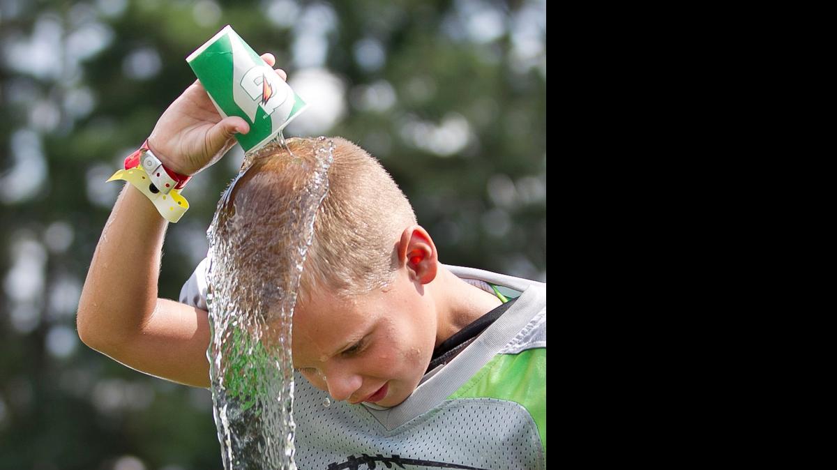 
Seven-year-old Trey Martin of New Bern  cools off with a cup of water at the Offense-Defense Football Camp at N.C. State University on Tuesday in Raleigh. The  camp is an independent group that rents facilities from the university. It has been holding camps for seven years in Raleigh as well as around the country. This week, campers will spend 12 hours a day working on their football skills. The 109 campers get water breaks every 15 minutes to keep them hydrated.
