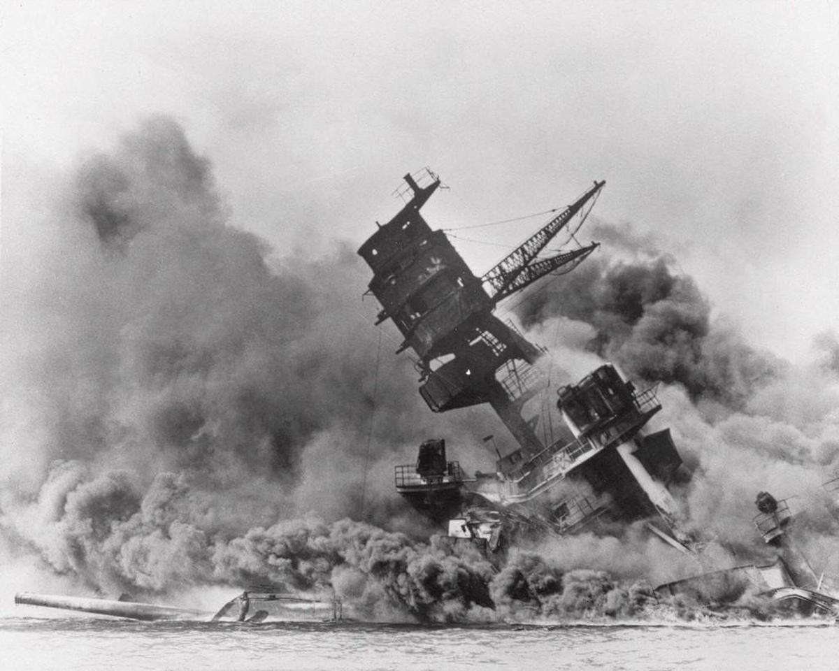 The battleship USS Arizona belches smoke as it topples over into the sea during a Japanese surprise attack on Pearl Harbor, Hawaii, Dec. 7, 1941.