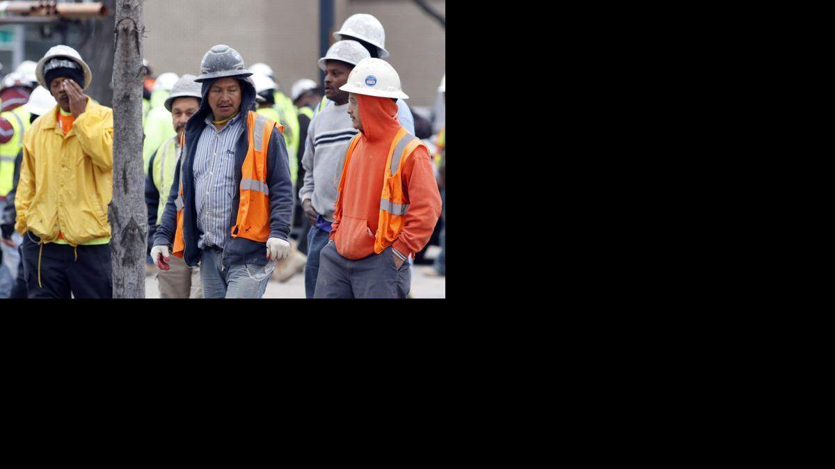 Stunned workers leave the scene of a construction accident that killed at least three workers Monday in Raleigh. A scaffold collapsed from several stories up at the Charter Square construction project.