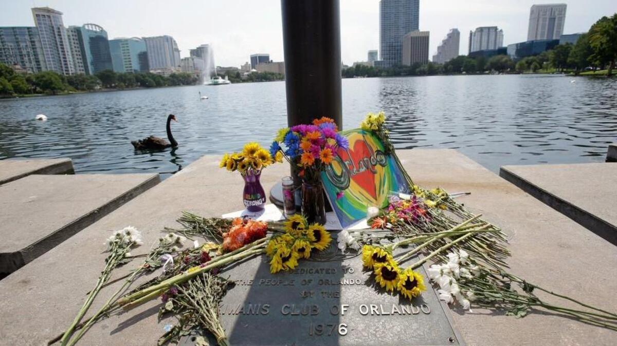 Flowers, candles and homemade signs surround a small makeshift memorial at Lake Eola park for the victims of the Pulse nightclub where many victims were killed on Sunday, Monday, June 13, 2016, in Orlando, Fla. (AP Photo/John Raoux)
