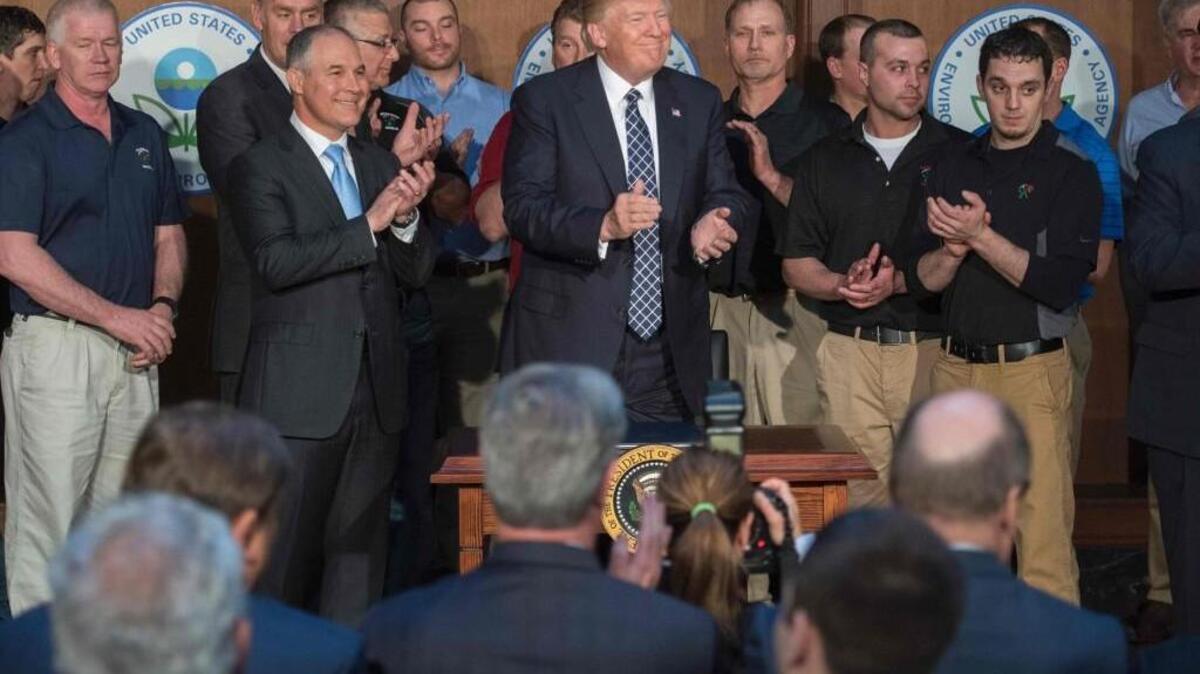 Surrounded by miners from Rosebud Mining, US President Donald Trump (C) applauds after signing the Energy Independence Executive Order at the Environmental Protection Agency (EPA) Headquarters in Washington, DC, March 28, 2017. President Donald Trump claimed an end to the “war on coal” Tuesday, as he moved to roll back climate protections enacted by predecessor Barack Obama.