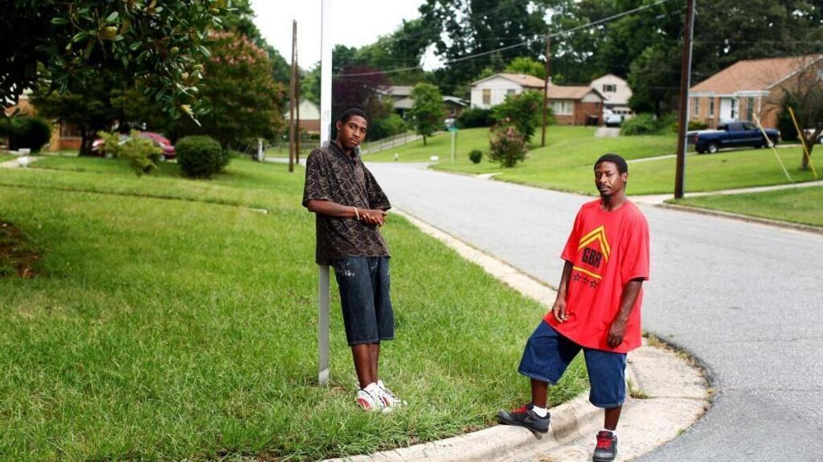 Brothers Devin, left, and Rufus Scales stand on the street corner where they were stopped while walking to the grocery store, in Greensboro, August 10, 2015. In North Carolina, the state that keeps the most comprehensive statistics, Greensboro officers pulled over, searched and used force on black drivers at a disproportionate rate.