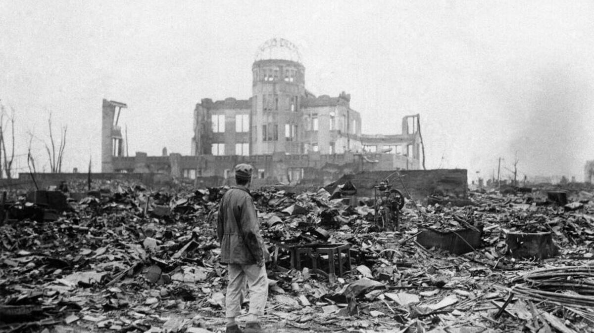 In this Sept. 8, 1945 file photo, an allied correspondent stands in the rubble in front of the shell of a building that once was a movie theater in Hiroshima, Japan, a month after the first atomic bomb ever used in warfare was dropped by the U.S. on Monday, Aug. 6, 1945. (AP Photo/Stanley Troutman, File)