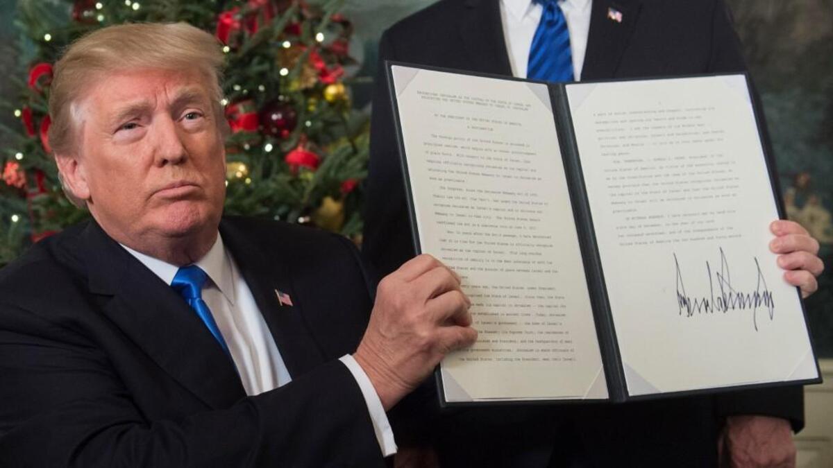 US President Donald Trump holds up a signed memorandum after he delivered a statement on Jerusalem from the Diplomatic Reception Room of the White House in Washington, DC on December 6, 2017. President Donald Trump on Wednesday recognized the disputed city of Jerusalem as Israel's capital, a historic decision that overturns decades of US policy and risks triggering a fresh spasm of violence in the Middle East.