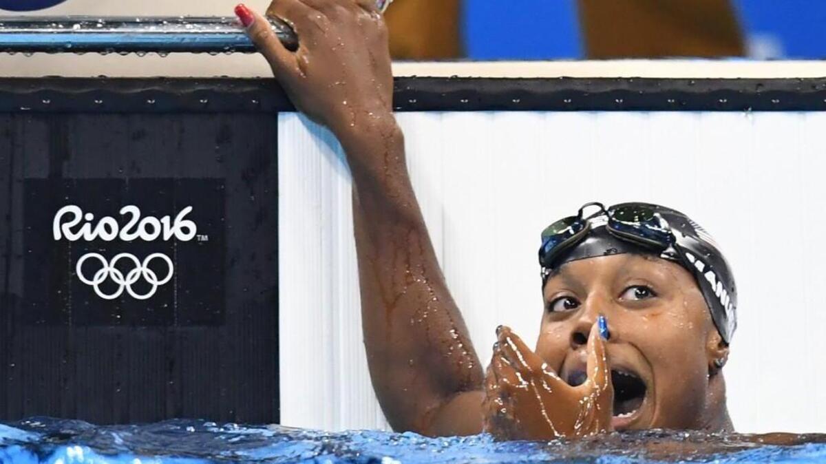 U.S. swimmer Simone Manuel sees her first-place finish on the scoreboard in the women’s 100m freestyle at the Olympic Aquatics Stadium in Rio. She became the first African-American woman to win a swimming gold for the United States.