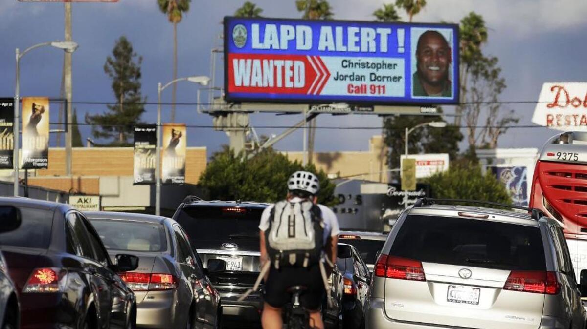 In this 2013 photo, commuters on Santa Monica Boulevard on the Westside of Los Angeles see a digital billboard displaying a large “wanted” poster.