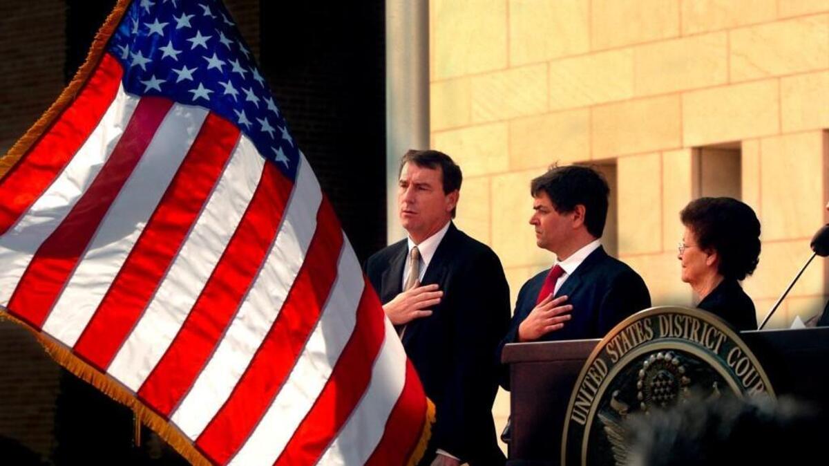 FILE- In this Nov. 14, 2005, file photo, U.S. Southern District Judge Andrew S. Hanen, left, joins with Filemon B. Vela, Jr. and Blanca Vela for the Pledge of Allegiance during the United States Courthouse naming ceremony in Brownsville, Texas. Hanen temporarily blocked President Barack Obama’s executive action on immigration Monday, Feb. 16, 2015, giving a coalition of 26 states time to pursue a lawsuit that aims to permanently stop the orders. (AP Photo/The Brownsville Herald, Brad Doherty, File)