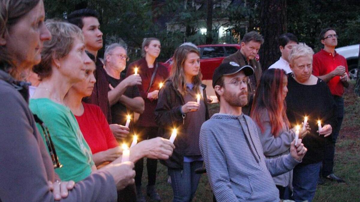 People hold candles in Oval Park in Durham during a Religious Coalition for a Nonviolent Durham vigil for Raluca Iosif, who was shot to death last year at her West Durham home.
