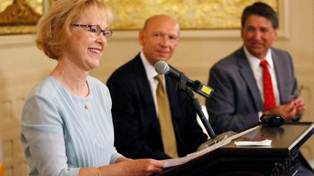 Outgoing NC DHHS Secretary Aldona Wos, left, thanks staffers in the audience for their hard work as Rick Brajer and Gov. Pat McCrory listen during a press conference Aug. 5. McCrory introduced Rick Brajer as his choice to replace Wos.