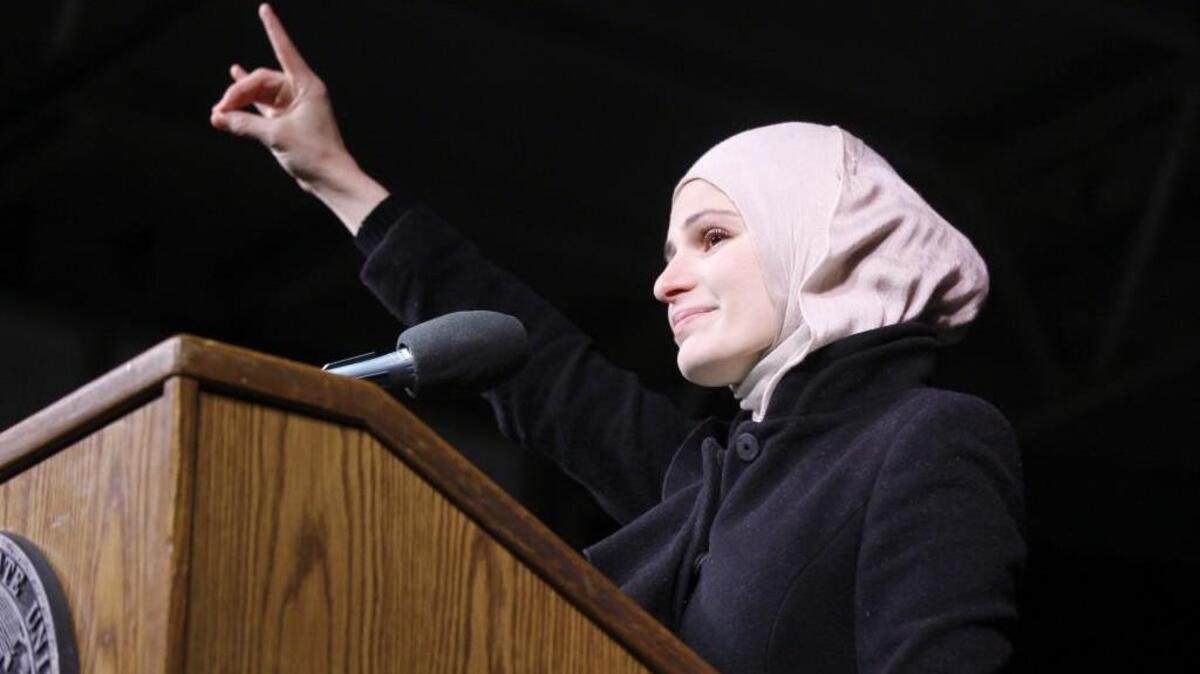 Suzanne Barakat speaking at N.C. State during a vigil for her brother, his wife and her sister after their slayings early last year.