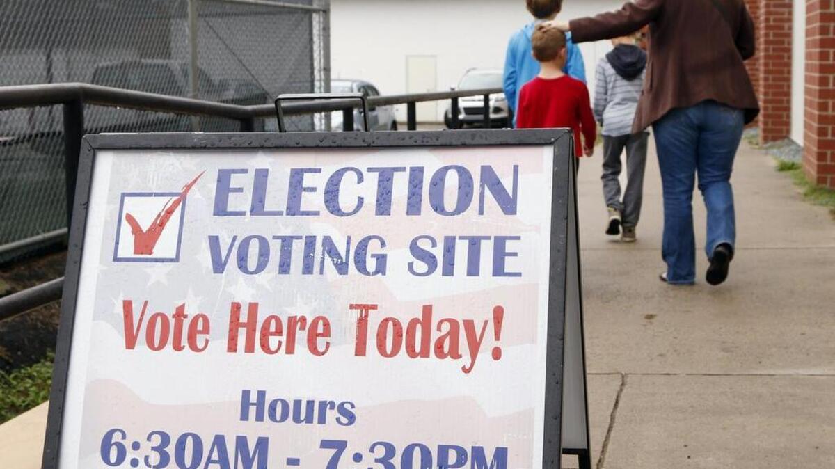 A mom and her three kids leave the Chapel Hill High School/North Carrboro precinct polling place after she voted Tuesday, Nov. 3, 2015 in the Orange County municipal elections.