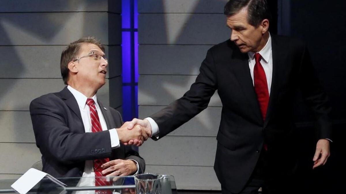 Candidates for Governor of North Carolina Pat McCrory (R), left, shakes hands with Roy Cooper (D) at the end of a debate at WRAL studios in Raleigh.