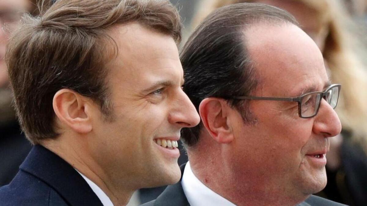 Outgoing French President Francois Hollande (R) stands by President-elect Emmanuel Macron (L) as they attend a ceremony marking the 72nd anniversary of the victory over Nazi Germany during World War II on May 8, 2017 in Paris.