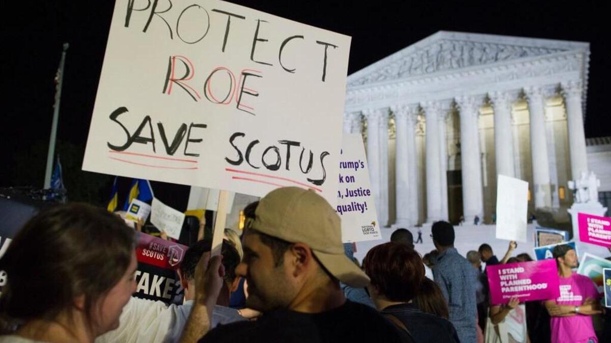 FILE - In this July 9, 2018 file photo, demonstrators holds signs as they gather in front of the Supreme Court in Washington after President Donald Trump announced Judge Brett Kavanaugh as his Supreme Court nominee. Worried by the prospect of a reconfigured court, abortion-rights advocates are intensifying efforts to ensure access to abortion for women who might be affected by a new wave of bans and restrictions. (AP Photo/Cliff Owen, File)