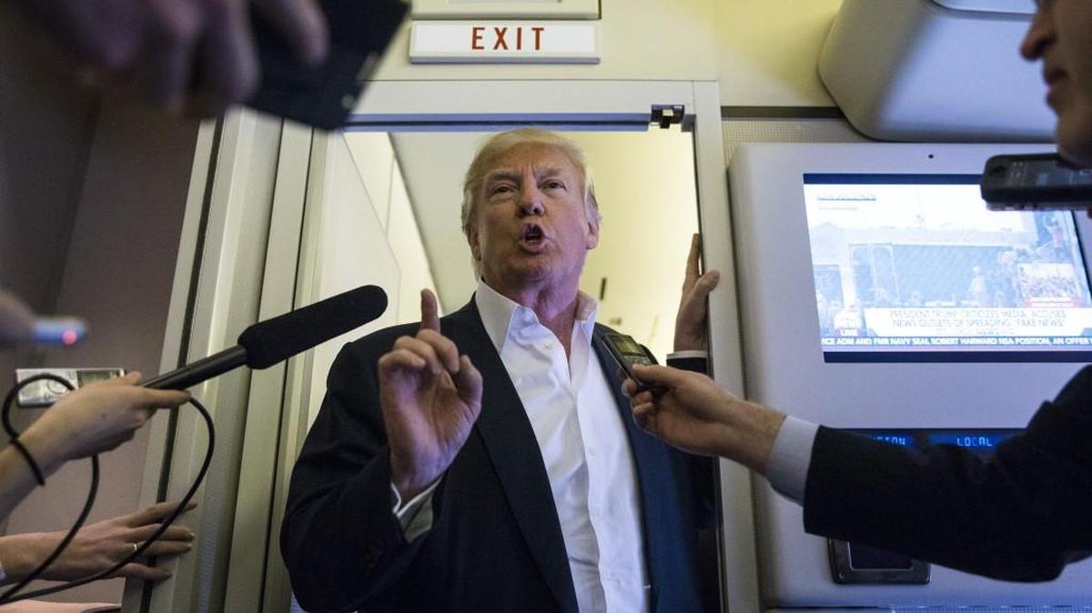 President Donald Trump speaks with reporters in the press cabin of Air Force One before a rally at Orlando Melbourne International Airport, in Melbourne, Fla., Feb. 18, 2017.