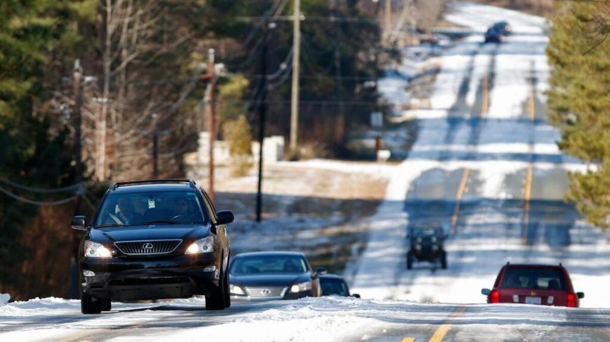 Northbound, left, and southbound morning traffic on Manns Chapel Road at Great Ridge Parkway creeps along in northern Chatham county, NC on the still ice and snow covered secondary road, Wednesday, February 18, 2015.