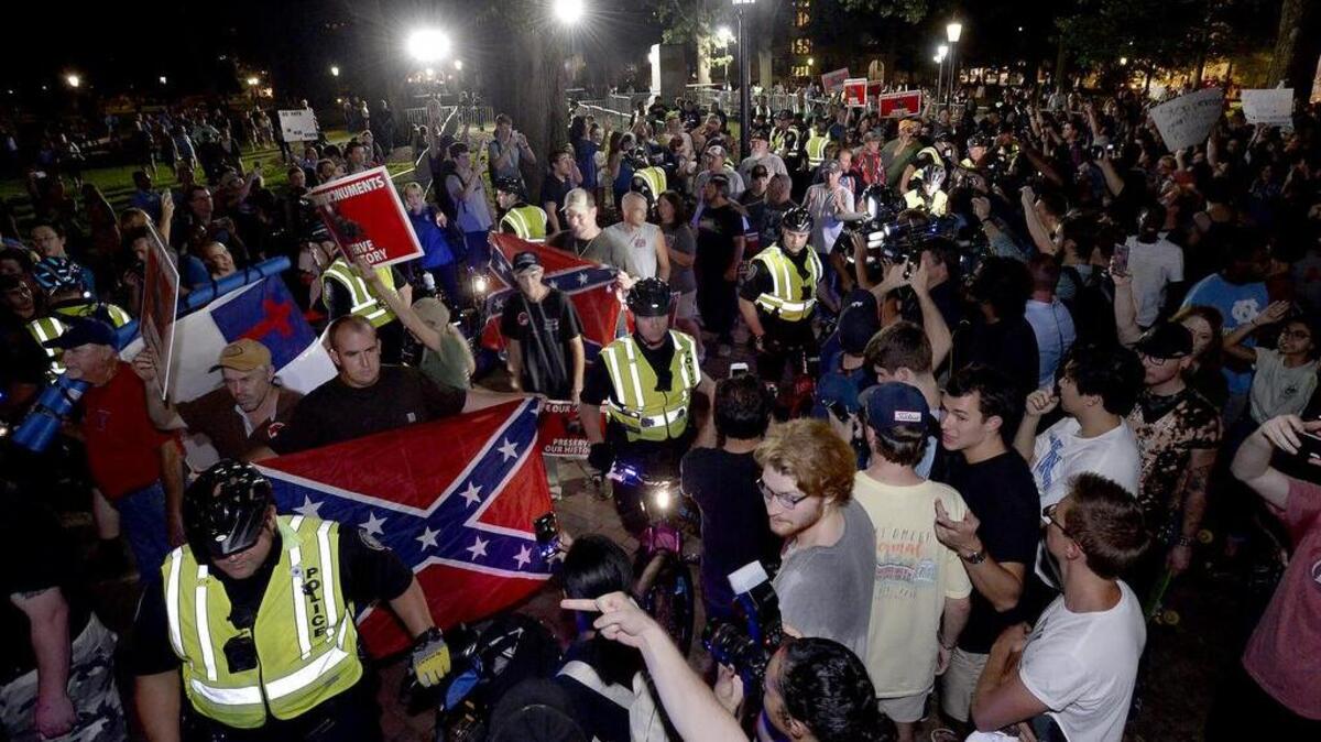 Members of ACTBAC and protesters face off at McCorkle Place on the campus of UNC-Chapel Hill, Thursday, August 30, 2018 as they leave a rally to commemorate the Silent Sam by the Alamance County based group. Bicycle police formed a wall between the group and protesters.