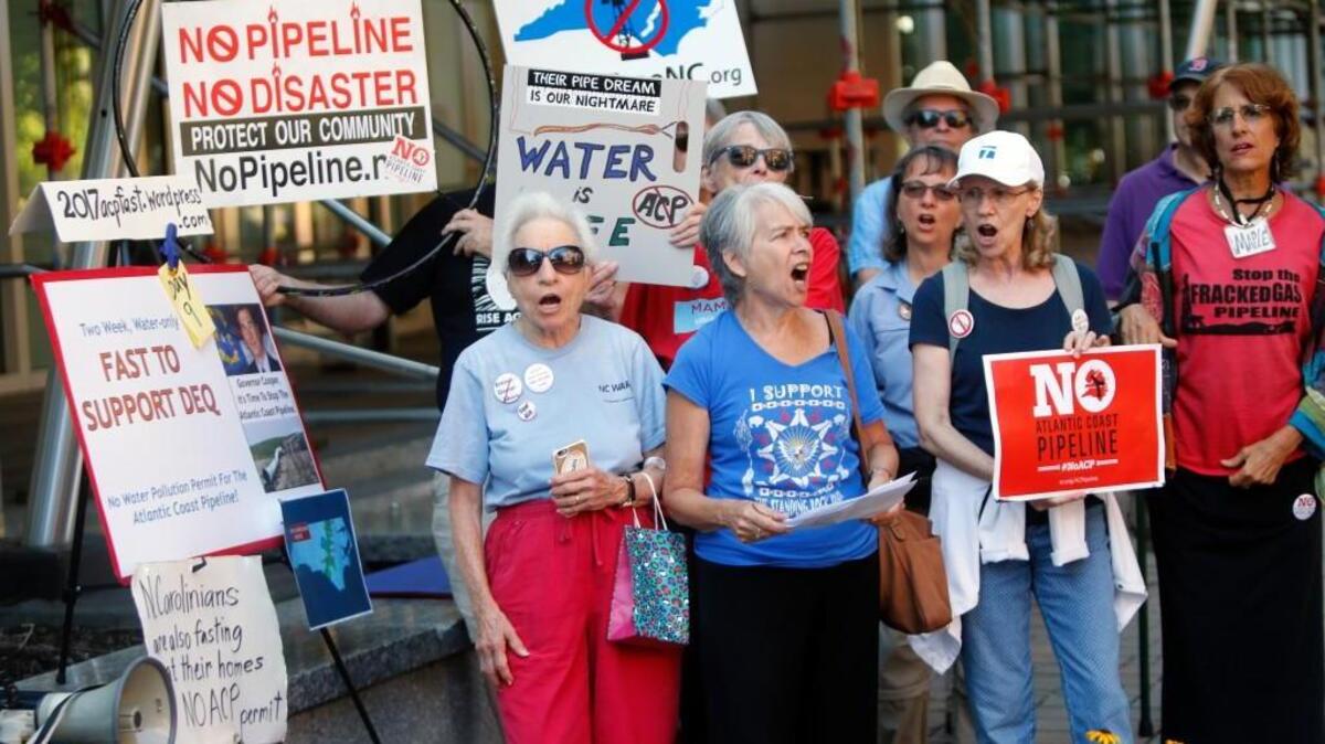 The raging grannies, minus their costumes, sing as they join a couple dozen other protesters around lunchtime to try to convince the N.C. Dept. of Environmental Quality to not approve permits that would allow the natural gas Atlantic Coast Pipeline to be built. Activist Greg Yost from Buncombe Co. is on day 9 of a 14 day water-only fast to protest against the the proposed pipeline which is being considered to transport natural gas through North Carolina. They all were in front of the N.C. Dept. of Environmental Quality offices in downtown Raleigh on Sept. 13, 2017.