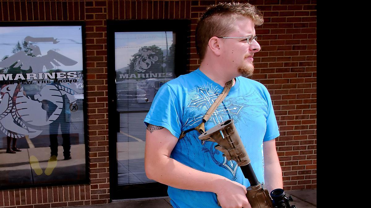 
Joshua B. Van Natter stands outside a military recruiting center in Logan, Utah. Gun-toting citizens are showing up at military recruiting centers around the country, saying they plan to protect recruiters following last week's killing of four Marines and a sailor in Chattanooga, Tenn. 
