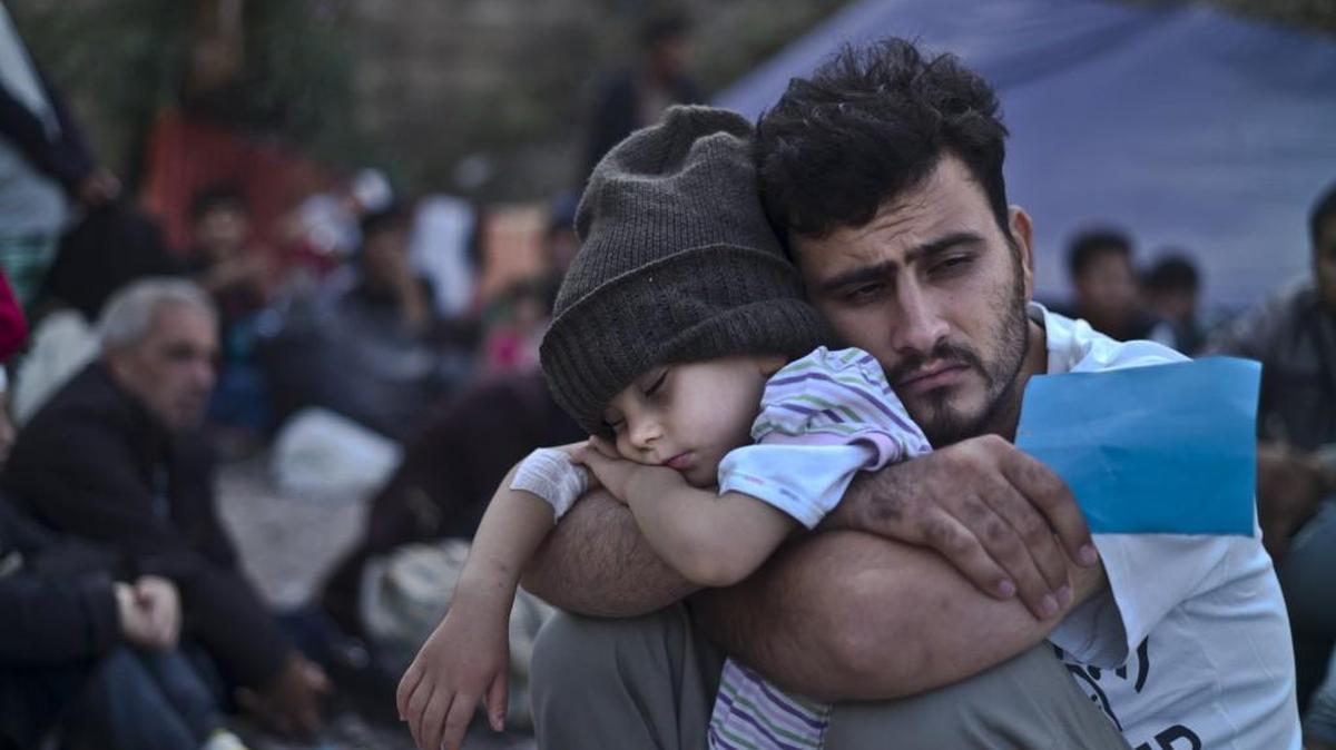 A Syrian refugee child sleeps in his father’s arms while waiting to board a bus last month after arriving on a dinghy from the Turkish coast to the northeastern Greek island of Lesbos.