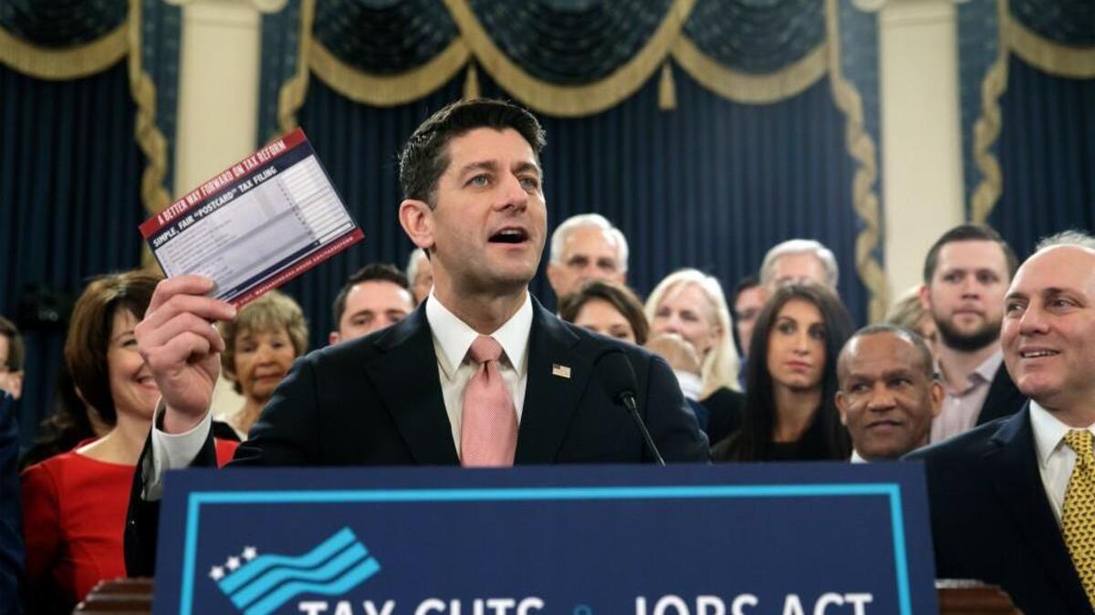 Speaker of the House Paul Ryan, R-Wis., with House Majority Whip Steve Scalise, R-La., far right, holds a proposed "postcard tax filing form" as they unveil the GOP's far-reaching tax overhaul, the first major revamp of the tax system in three decades, on Capitol Hill in Washington, Thursday, Nov. 2, 2017.
