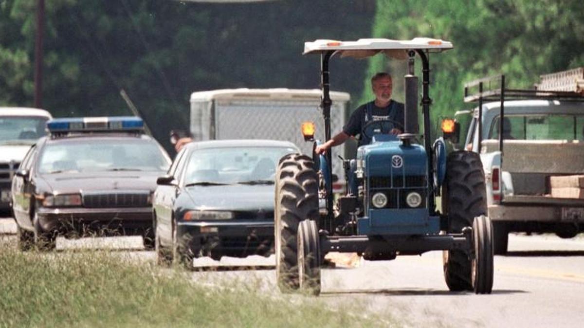 Tommy Ward makes his best speed going east along Hwy. 54 in Orange Co. toward Carrboro Tuesday afternoon. Even so, traffic backs up periodically behind the slow moving tractor.