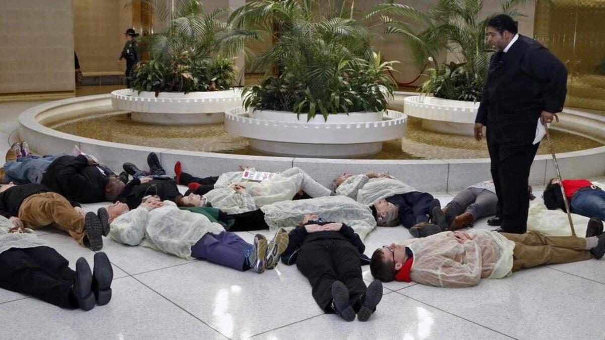 Rev. William Barber, head of the NC NAACP, standing, prays over 13 protesters who participated in a die-in at under the rotunda of the NC Legislature Thursday afternoon, February 12, 2015. The protestors were rallying to protest the state's continued denial of Medicaid expansion for hundreds of thousands of North Carolinians. The protesters were from the NC NAACP and the Forward Together Moral Movement. Donald Trump’s election may end any chance for expansion.