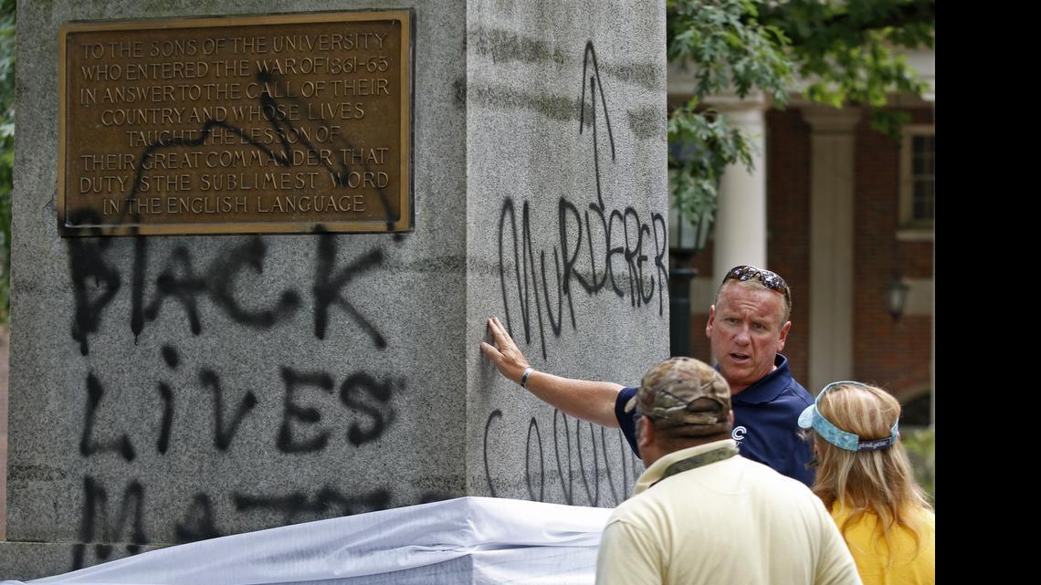 
Mike Coleman, general manager of CCI Environmental Services, touches the base of the Silent Sam statue on the UNC-CH campus as he evaluates the black spray paint damage.
