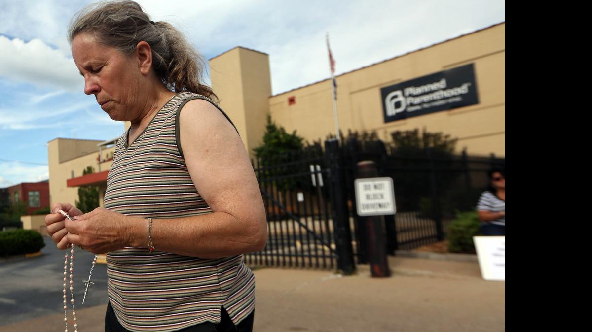 
Mary Roy of Potosi, Mo., holds a rosary at a pro-life rally outside a Planned Parenthood building in St. Louis. Anti-abortion activists on Tuesday released a second undercover video aimed at discrediting Planned Parenthood's procedures for providing fetal tissue to researchers. 
