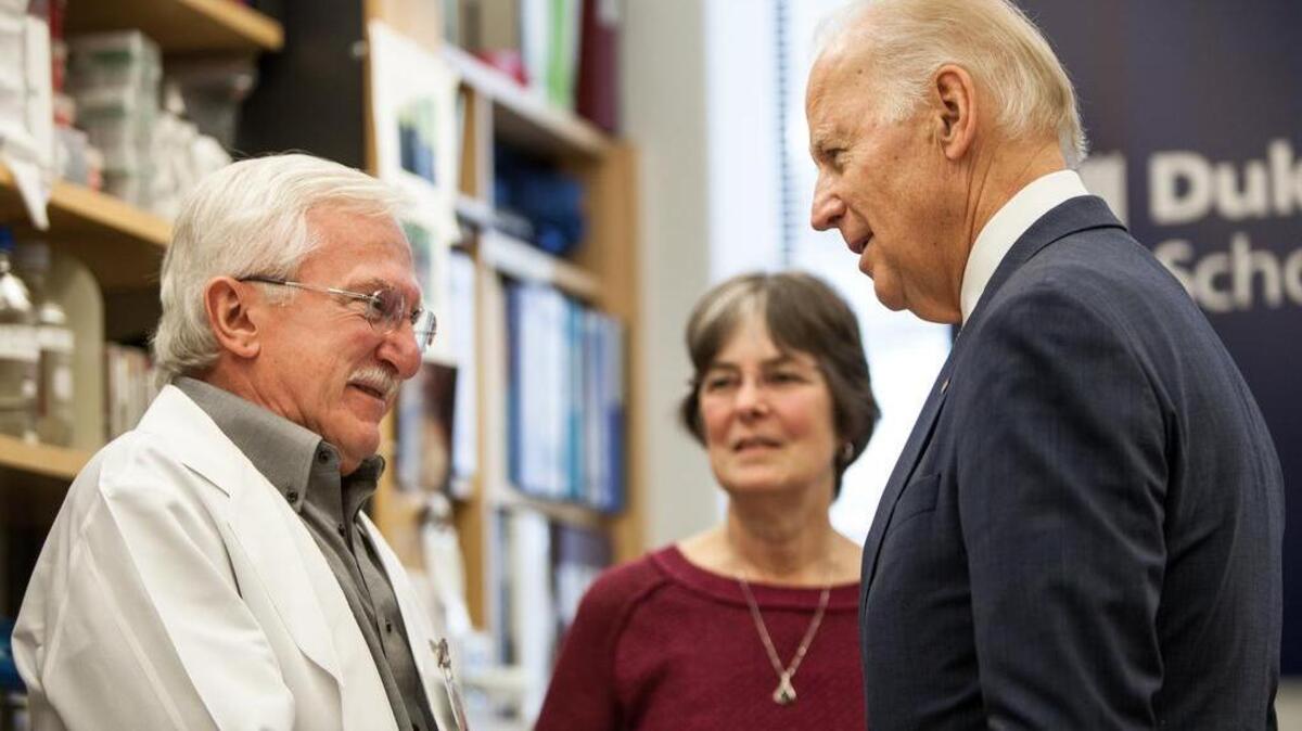 Vice President Joe Biden speaks with Nobel Laureate Dr. Paul Modrich, left, as Vickers Burdett, wife of Dr. Modrich, middle, listens in a laboratory at Duke University School of Medicine. Biden visited Duke to speak about his Cancer Moonshot initiative.