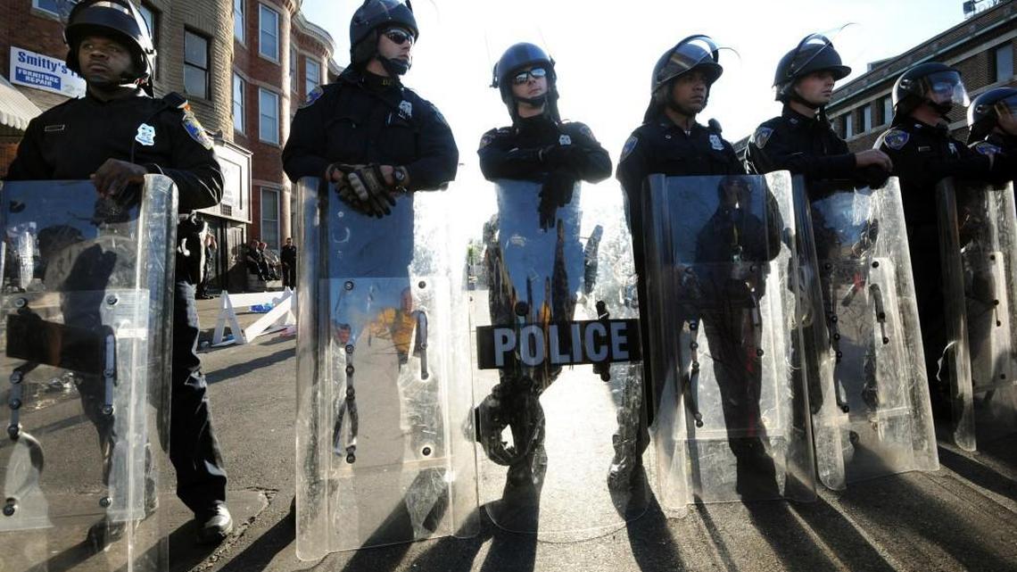 Baltimore police stand watch 24 hours after the riots sparked by the death of Freddie Gray in April in Baltimore, Md. The Department of Justice on Aug. 10 released a report saying Baltimore police routinely violated constitutional rights of residents.