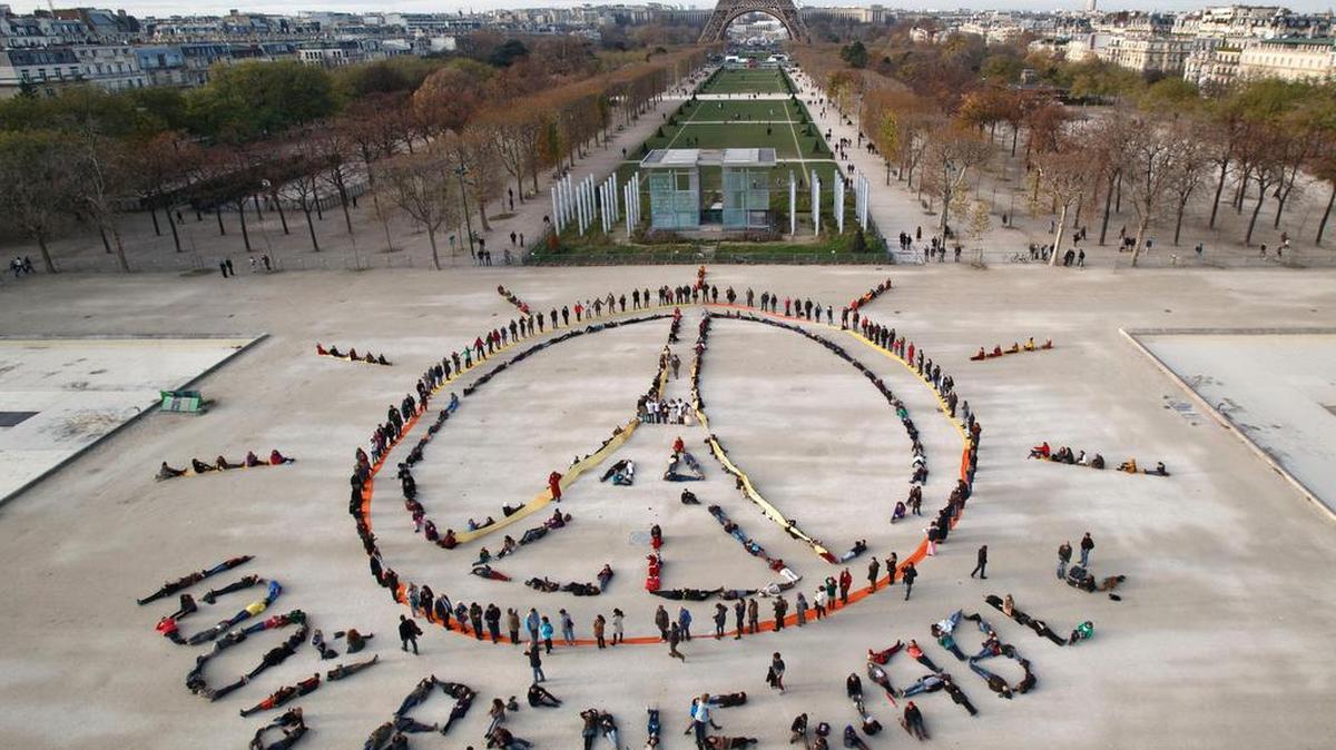 Environmentalist activists form a human chain on the side line of the United Nations Climate Change Conference near the Eiffel Tower in Paris.