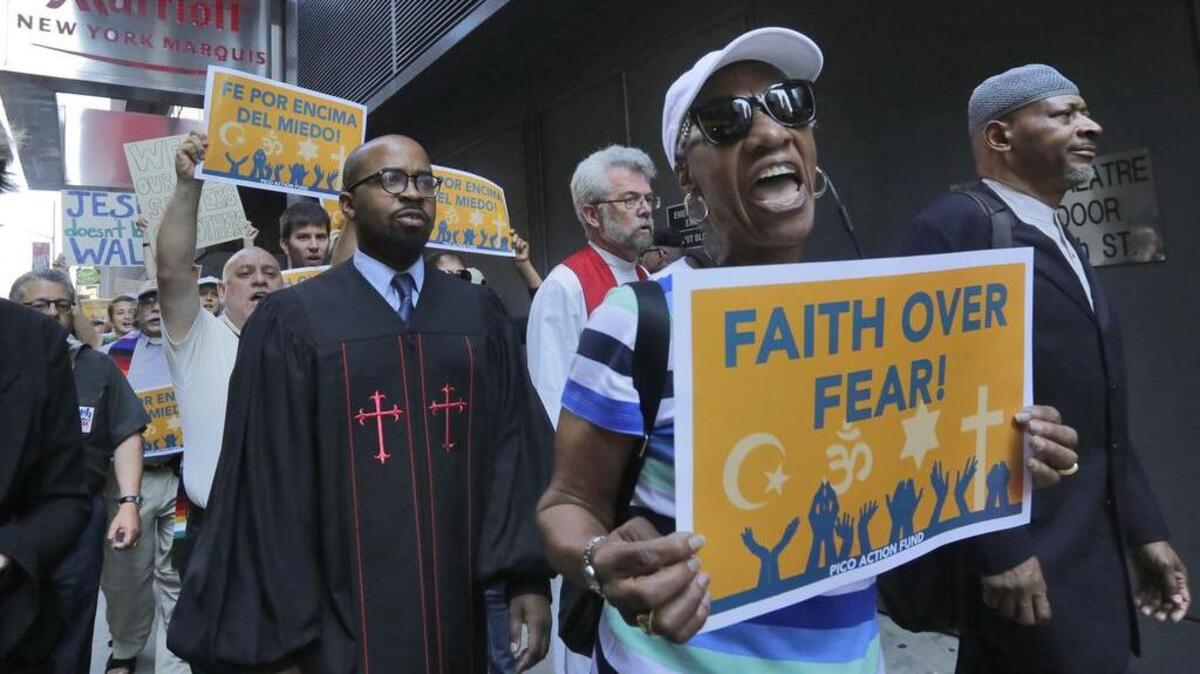 Clergy leaders with PICO (People Improving Communities through Organizing) Action Fund and their local federation, Faith in New York, demonstrate outside the hotel in New York’s Times Square where Republican presidential candidate Donald Trump met evangelical clergy.