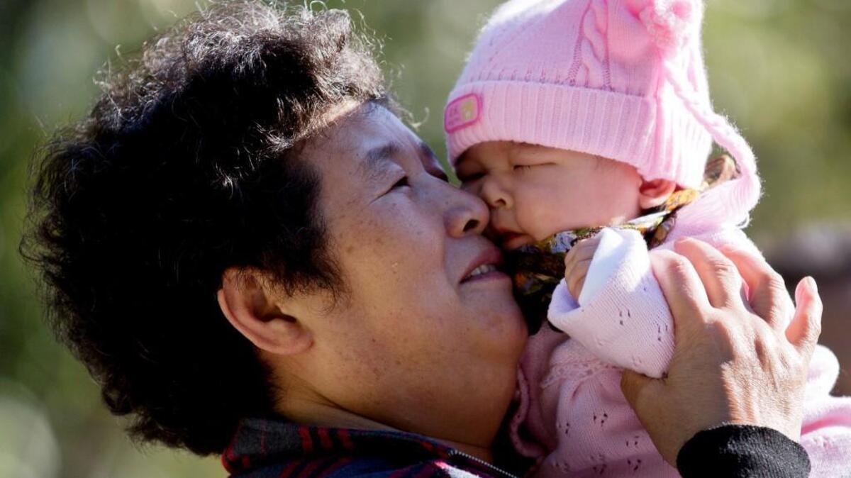 A Chinese woman plays with her grandchild at the Ritan Park in Beijing. China’s ruling Communist Party announced that it will allow all couples to have two children now.