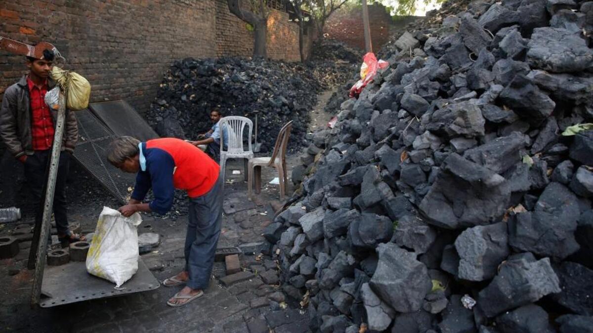 A vendor weighs coal in Lucknow, India, on Dec. 3. Reaching the climate deal goals may be impossible.